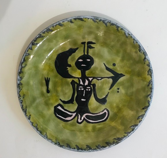 assiette à décor de personnages sur fond vert 